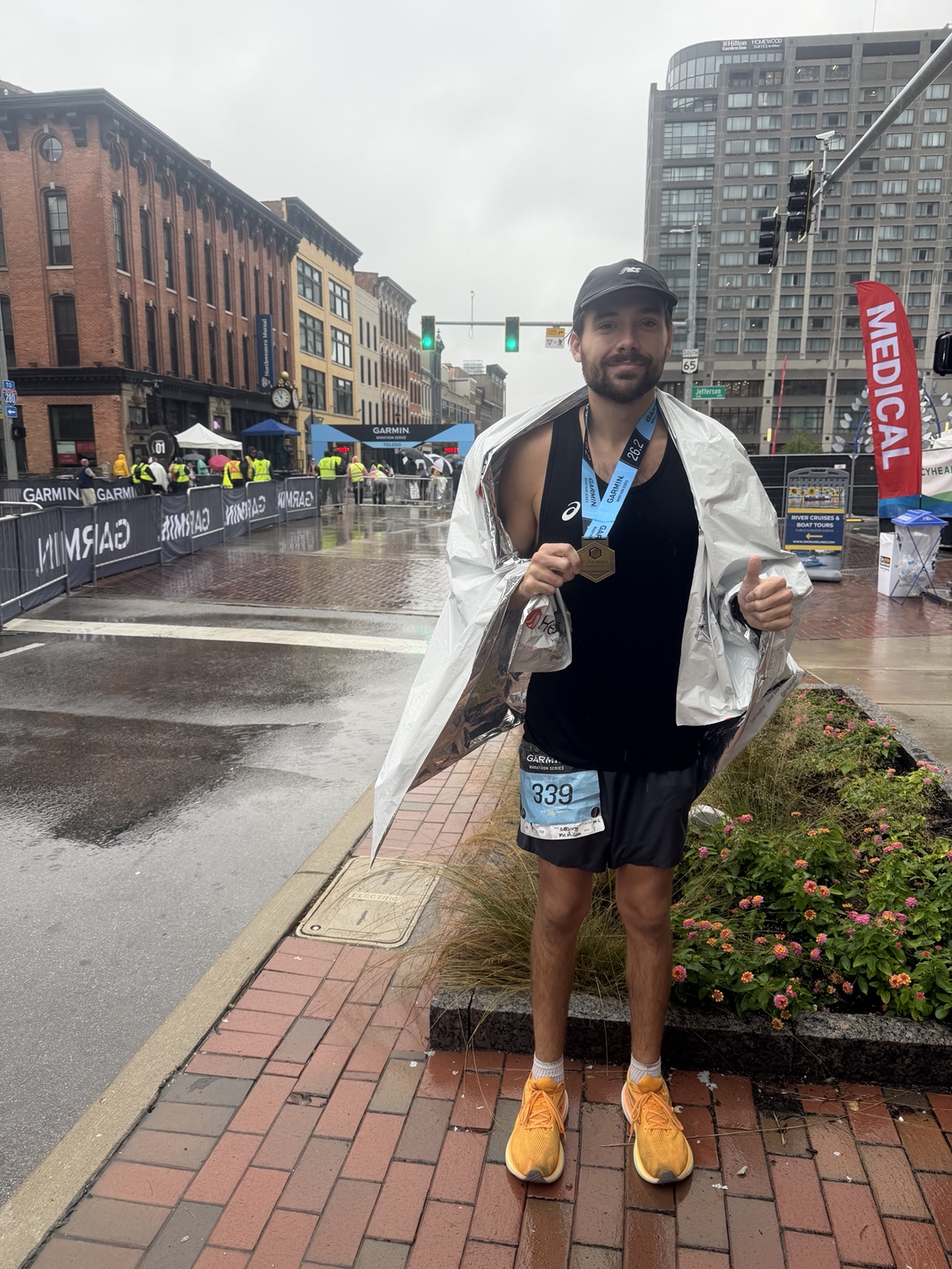 Greg wearing a marathon medal after finishing in the rain